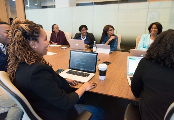 Cyber insurance requirements business review Business team reviewing cyber insurance requirements together on laptops in a conference room